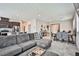 Spacious living room with tile floors, grey sectional sofa, dining area, and an open layout at 4423 Creekside Cavern Ave, North Las Vegas, NV 89084