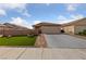 Exterior front view of a beige single-story home featuring a manicured lawn and brick paved walkway at 4611 Julesburg Dr, Las Vegas, NV 89139