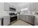 Well-equipped kitchen with stainless steel appliances, sleek countertops, and contemporary gray cabinetry at 4611 Julesburg Dr, Las Vegas, NV 89139