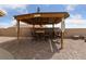 Backyard tiki bar, featuring a table, chairs, decorative surfboards and paved patio at 4611 Julesburg Dr, Las Vegas, NV 89139