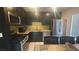 Modern kitchen featuring stainless steel appliances, dark cabinetry, and granite countertops at 4868 Treetrunk Ave, Las Vegas, NV 89147