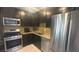 Updated kitchen features stainless steel appliances and granite countertops at 4868 Treetrunk Ave, Las Vegas, NV 89147