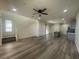 Spacious living room featuring wood flooring, a staircase, and an open layout flowing into the adjacent kitchen area at 492 Pear Lake St, Las Vegas, NV 89138