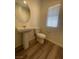 Powder room featuring pedestal sink, toilet, and wood flooring at 492 Pear Lake St, Las Vegas, NV 89138