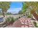 Lovely landscaped backyard with a stone path, mature trees, and wrought iron fence at 4932 Forest Oaks Dr, Las Vegas, NV 89149