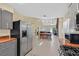 Modern kitchen with a view to the living and dining spaces, featuring stainless appliances and dark cabinets at 4932 Forest Oaks Dr, Las Vegas, NV 89149