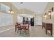 Open-concept dining and living area featuring vaulted ceilings, natural light, and modern kitchen nearby at 4932 Forest Oaks Dr, Las Vegas, NV 89149