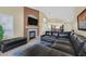 Inviting living area with fireplace, large sectional sofa, and seamless flow to dining and kitchen at 4932 Forest Oaks Dr, Las Vegas, NV 89149