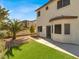 Home with landscaped backyard featuring grass, palm tree, and a patio at 5120 First Sun St, North Las Vegas, NV 89081