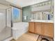 Bright bathroom featuring a double sink vanity, shower, and soaking tub at 5120 First Sun St, North Las Vegas, NV 89081