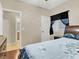 Well-lit bedroom with hardwood floors, ceiling fan, dresser, and a view into the bathroom at 5120 First Sun St, North Las Vegas, NV 89081