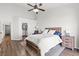 Cozy bedroom featuring a ceiling fan, white walls, wood floors and a comfortable bed with white linens at 5227 Zebra Ct, North Las Vegas, NV 89031
