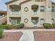 Beige condo building featuring a multi-level facade, balconies, and well-kept landscaping at 5415 W Harmon Ave # 1074, Las Vegas, NV 89103