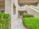 Close-up of a stucco condo building exterior featuring arched windows, stairs, and green landscaping at 5415 W Harmon Ave # 1074, Las Vegas, NV 89103