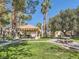 Community gazebo with tables and benches, surrounded by green grass and mature trees on a sunny day at 5415 W Harmon Ave # 1074, Las Vegas, NV 89103
