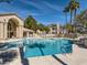 Large community pool with clear blue water, surrounded by lounge chairs and palm trees on a sunny day at 5415 W Harmon Ave # 1074, Las Vegas, NV 89103