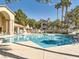 Large community pool, lounge chairs, and clear blue water surrounded by palm trees and other buildings at 5415 W Harmon Ave # 1074, Las Vegas, NV 89103