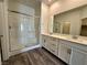 Modern bathroom featuring a glass shower, double sink vanity with white cabinets, and wood-look flooring at 545 Thea St # 1315, Henderson, NV 89052