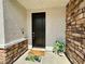 Front door with stone accents, modern house number, welcoming door mats and green plants at 545 Thea St # 1315, Henderson, NV 89052