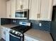 Modern kitchen with stainless steel appliances and stylish blue subway tile backsplash at 545 Thea St # 1315, Henderson, NV 89052