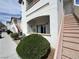 Exterior angle of a multi-level condo with stairs and a sidewalk with green bushes and a door on the first level at 5650 E Sahara Ave # 1035, Las Vegas, NV 89142