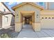 Inviting covered porch with decorative columns, lighting and concrete path to the two-car garage at 5808 Sierra Cliff St, North Las Vegas, NV 89031