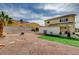 Wide shot of a backyard with artificial turf, decorative rocks, and privacy fencing at 6538 Astorville Ct, Las Vegas, NV 89110