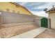 Backyard exterior featuring a cemented wall and a gate covered with foliage for added privacy and charm at 6538 Astorville Ct, Las Vegas, NV 89110