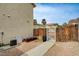 Sideyard exterior with a weathered wood fence, arbor entrance, and partial view of the property's landscape at 6538 Astorville Ct, Las Vegas, NV 89110