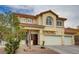 A view of a two-story stucco home featuring a red tile roof, desert landscaping, and a three-car garage at 6538 Astorville Ct, Las Vegas, NV 89110