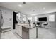 Modern kitchen with an island, stainless steel dishwasher, marble floors, and views into the dining area and staircase at 6538 Astorville Ct, Las Vegas, NV 89110