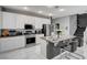 Contemporary kitchen featuring an island with bar stools, white cabinets, and stainless appliances at 6538 Astorville Ct, Las Vegas, NV 89110