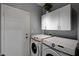 Laundry room featuring a white washer and dryer, cabinets, and a door to the outside at 6538 Astorville Ct, Las Vegas, NV 89110