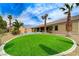Expansive backyard boasts a lush green lawn, desert landscaping, a sparkling pool, and ample space for outdoor enjoyment at 6971 Moaning Cavern St, Las Vegas, NV 89131