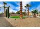 Beautifully landscaped backyard showcasing a circular lawn, mature palm trees, and well-maintained desert landscaping at 6971 Moaning Cavern St, Las Vegas, NV 89131