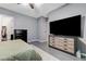 Bedroom featuring a large television, tiled floor, and modern furnishings for comfortable living at 6971 Moaning Cavern St, Las Vegas, NV 89131