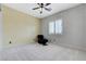 A bright bedroom featuring neutral carpeting, a ceiling fan, and natural light from the window at 6971 Moaning Cavern St, Las Vegas, NV 89131