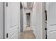 Hallway with white doors, tiled floors, and recessed lighting, creating a clean and bright space at 6971 Moaning Cavern St, Las Vegas, NV 89131
