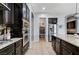Modern kitchen with stainless steel appliances, granite countertops and dark wood cabinetry at 6971 Moaning Cavern St, Las Vegas, NV 89131