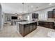 Open-concept kitchen with dark cabinets, granite countertops, and island seating at 6971 Moaning Cavern St, Las Vegas, NV 89131