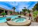 Stunning backyard with sparkling pool and spa, palm trees, rock features, and tranquil landscaping at 6971 Moaning Cavern St, Las Vegas, NV 89131