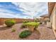 Low maintenance backyard features decorative rock, lush greenery, and a block wall fence at 7264 Summer Duck Way, North Las Vegas, NV 89084