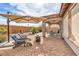 Brick patio backyard with an outdoor umbrella, fire pit and comfortable patio seating at 7264 Summer Duck Way, North Las Vegas, NV 89084
