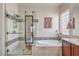 Bright bathroom featuring double sinks, a soaking tub, and a glass-enclosed shower at 7264 Summer Duck Way, North Las Vegas, NV 89084