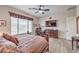 Bedroom with large window, ceiling fan, hardwood floors, and attached desk setup at 7264 Summer Duck Way, North Las Vegas, NV 89084