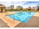 Community pool features clear blue water, umbrellas, lounge chairs, and mountain views at 7264 Summer Duck Way, North Las Vegas, NV 89084
