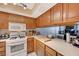 Classic kitchen features oak cabinets, white appliances, and ample counter space for meal preparation at 775 Cathy Ln, Henderson, NV 89015