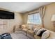 Cozy living room featuring a comfortable sectional, window with blinds, and built-in storage cabinet at 775 Cathy Ln, Henderson, NV 89015