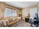 Comfortable living area with a sectional sofa, soft carpet, and bright natural light from the window at 775 Cathy Ln, Henderson, NV 89015