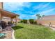 Large backyard featuring well-manicured lawn, mature hedges, and covered patio for outdoor enjoyment at 803 Fetter Ct, Henderson, NV 89052